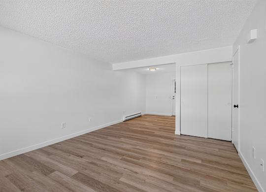 A room with wooden flooring and white walls.