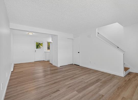A room with wooden flooring and white walls.