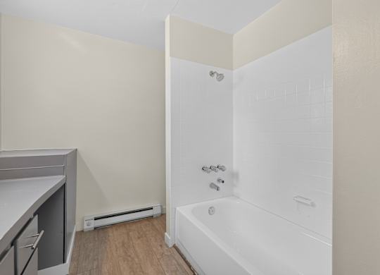 A white bathtub with a shower head and faucet.