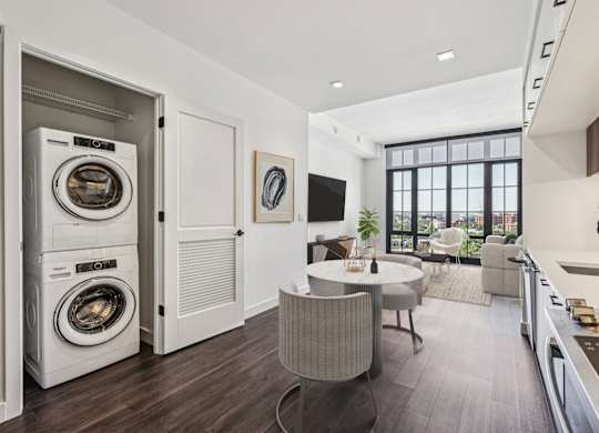 A modern laundry room with a washer and dryer built into the cabinetry.