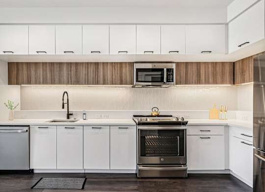 A modern kitchen with white cabinets and a wooden backsplash.