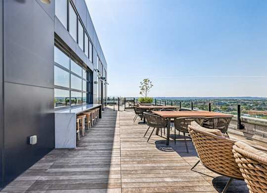 A patio with a table and chairs overlooking a cityscape.
