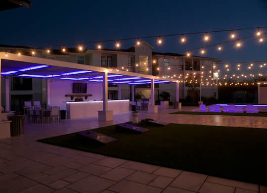 A patio area with a white pergola and string lights. at The Azul Apartment Homes, Oxford
