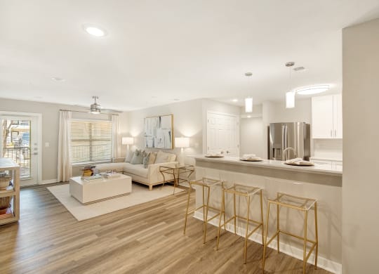 a living room with a kitchen and a couch and chairs at The Azul Apartment Homes in Oxford, 38655