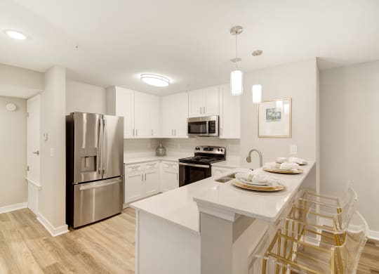 a kitchen with a large island and stainless steel refrigerator at The Azul Apartment Homes in MS 38655