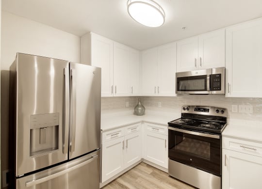 a kitchen with stainless steel appliances and white cabinets at The Azul Apartment Homes in Oxford, Mississippi 38655