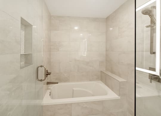 the ensuite bathroom has a tub and a shower at The Azul Apartment Homes in Oxford, MS 38655