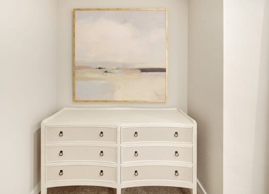 a white dresser with a painting on the wall above it at The Azul Apartment Homes in Oxford, Mississippi 38655
