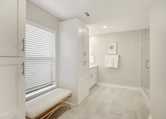 a large white bathroom with a shower and a bench at The Azul in Oxford, MS