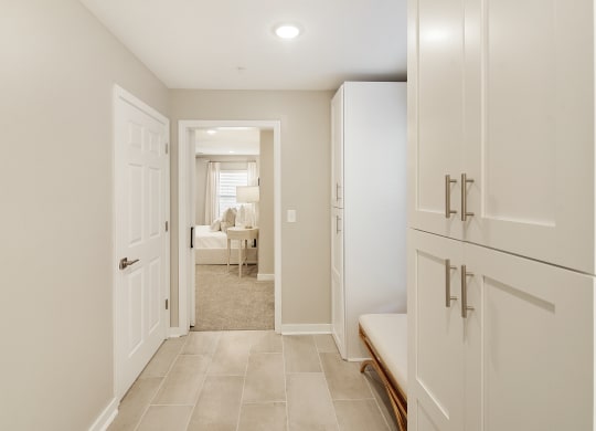 a white kitchen with white cabinets and white doors and a hallway to a living room at The Azul Apartment Homes, Oxford, Mississippi