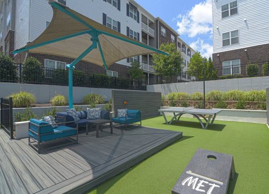 a rendering of a patio with furniture and a picnic table at The Met Apartment Homes, Mississippi