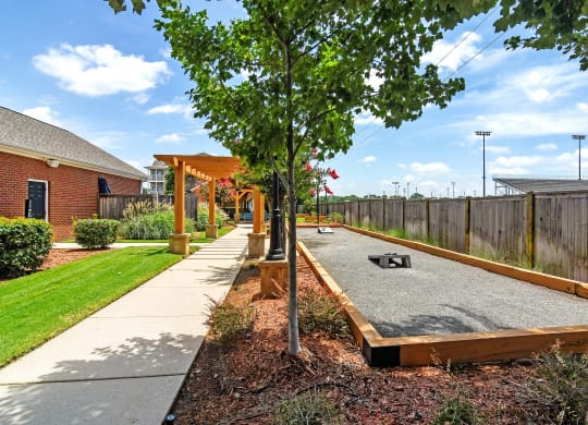 a tree in the middle of a sidewalk next to a fence at Summit of Shreveport Apartments, Louisiana 71105