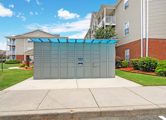 a small storage shed on a sidewalk in front of an apartment building at Summit of Shreveport Apartments, Shreveport
