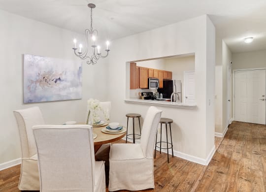 a dining room with a table and chairs and a kitchen at Summit of Shreveport Apartments, Shreveport