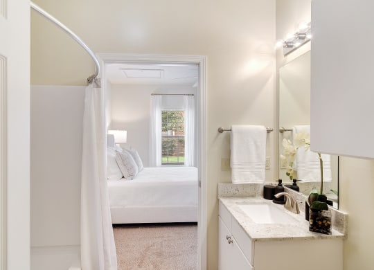 a bathroom with a sink and a mirror and a bedroom with a bed at Summit of Shreveport Apartments, Shreveport, LA, 71105