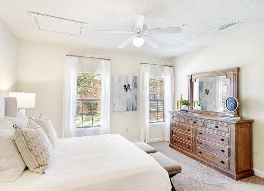 a bedroom with a large bed and a dresser at Summit of Shreveport Apartments, Shreveport, Louisiana