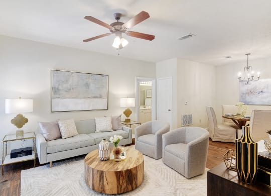 a living room with a couch and chairs and a ceiling fan at Summit of Shreveport Apartments, Shreveport, LA