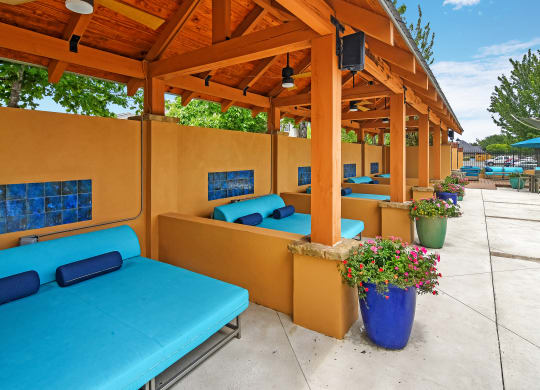 a group of cabanas with blue couches under a wooden roof at Summit of Shreveport Apartments, Louisiana 71105