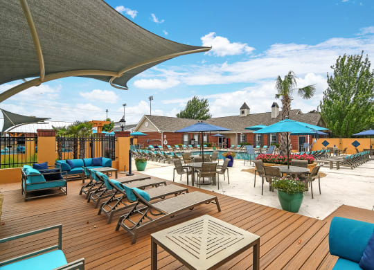 an outdoor patio with tables and chairs and umbrellas at Summit of Shreveport Apartments, Shreveport, LA, 71105