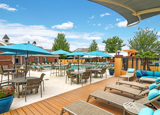 a patio with tables and chairs and umbrellas at Summit of Shreveport Apartments, Shreveport