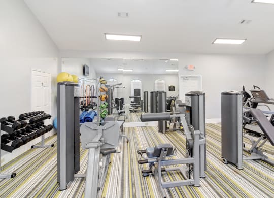 a gym with cardio machines and weights on the floor at Summit of Shreveport Apartments, Louisiana
