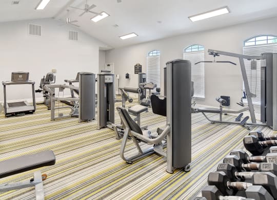 a fitness room with cardio machines and weights on the floor at Summit of Shreveport Apartments, Shreveport, LA