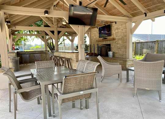 A patio with a table and chairs and a television.