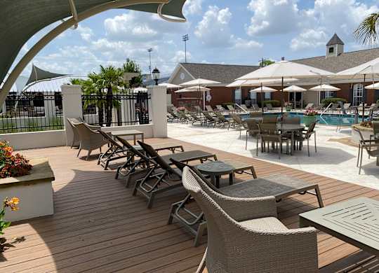 A poolside area with chairs and tables.