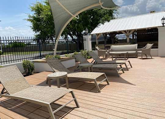 A patio with wooden decking and several chairs and tables.