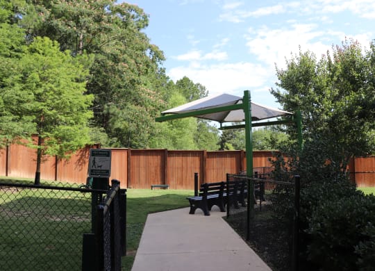 a picnic area in a park with a bench and a canopy at The Met Apartment Homes, Hattiesburg, 39402