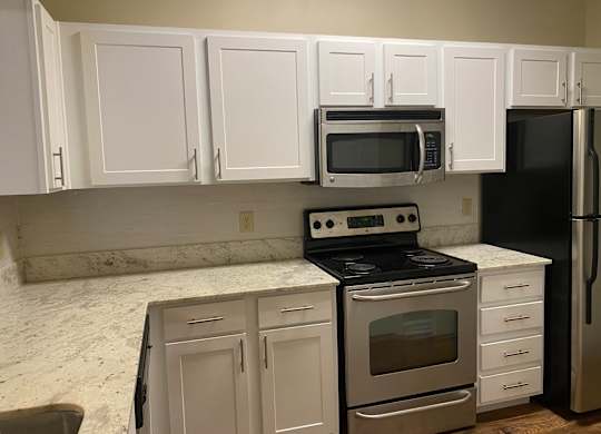 A kitchen with white cabinets and a black fridge at Summit of Shreveport Apartments, Shreveport, LA, 71105