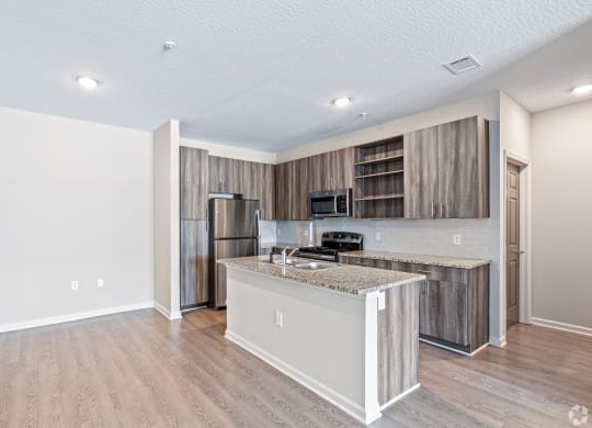 a kitchen with a island and a stainless steel refrigerator at The Met Apartment Homes, Hattiesburg, Mississippi