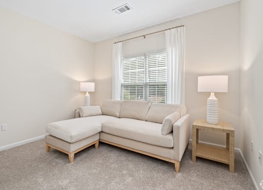 a living room with a couch and a window at The Met Apartment Homes, Hattiesburg, 39402