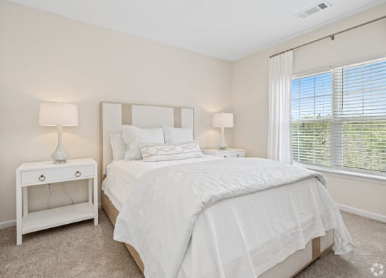 a bedroom with a large bed and a window at The Met Apartment Homes, Hattiesburg, MS, 39402
