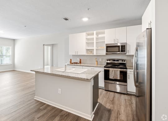a renovated kitchen with stainless steel appliances and white cabinets at The Met Apartment Homes, Hattiesburg, MS, 39402