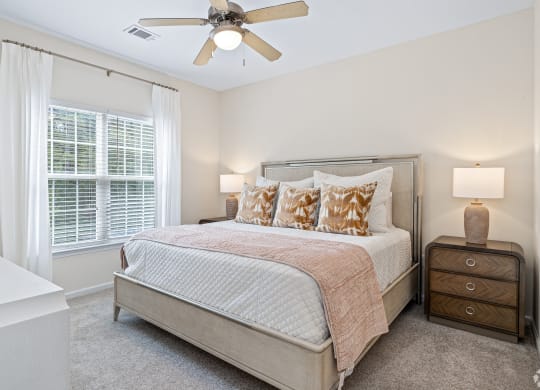 a bedroom with a bed and a ceiling fan at The Met Apartment Homes, Mississippi 39402