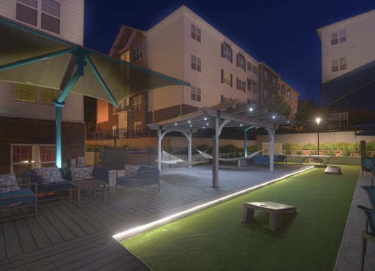 A patio area with a green lawn and a white umbrella at The Met Apartment Homes, Hattiesburg, MS, 39402