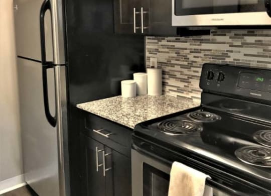 Modern kitchen with stainless steel appliances and modern backsplash at Camelot East Apartments, Fairfield, OH, 45014