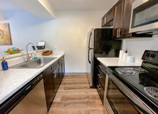 Spacious kitchen with faux wood flooring and stainless steel appliances at Camelot East Apartments, Fairfield, 45014