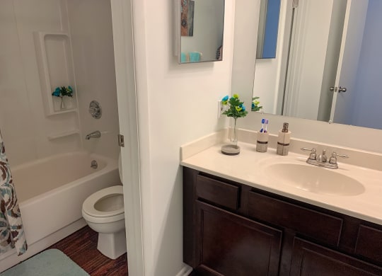 Modern bathroom with wood-style plank flooring at The Lodge Apartments in Indianapolis, IN
