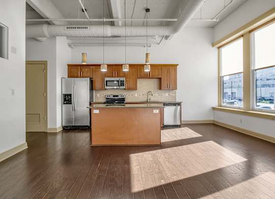 A kitchen with wooden cabinets and a large island. at 100 South Apartments, New York