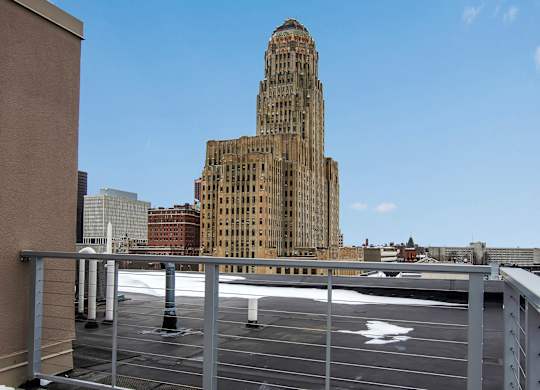 A tall building with a pointed top stands in the background of a cityscape. at 100 South Apartments, New York