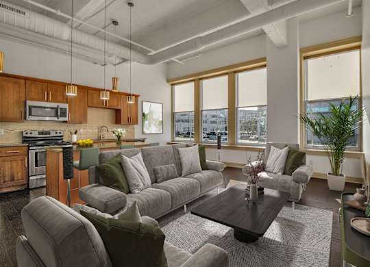 A modern living room with a grey sofa set and a wooden coffee table. at 100 South Apartments, New York, 14202