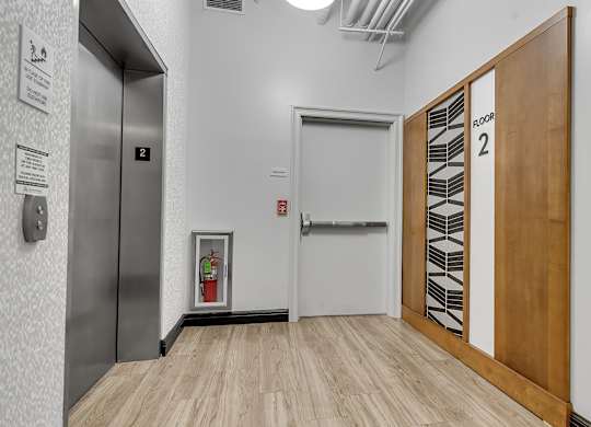 Elevator lobby with stairwell and fire extinguisher at 100 South Apartments, Buffalo, NY