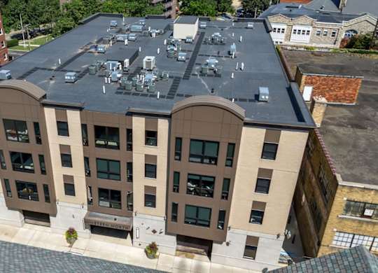 A large building with a flat roof and a parking lot in front.