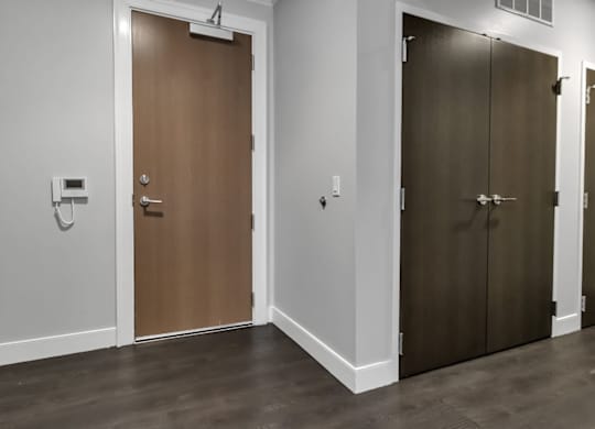 A room with two doors, one wooden and one brown.