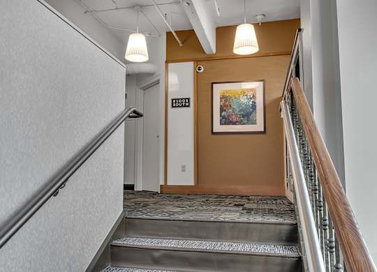 Interior stairwell with carpeted steps and artwork at 100 South Apartments, Buffalo