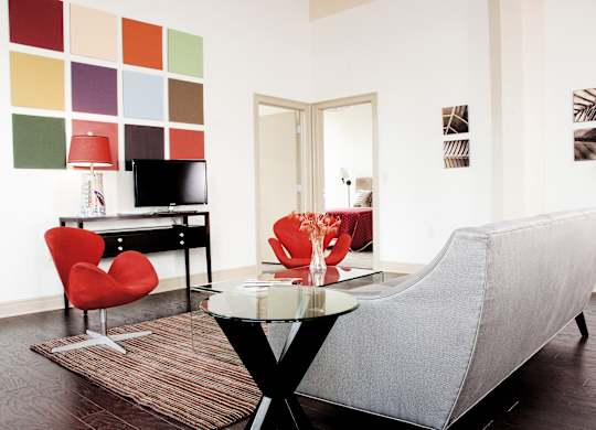 a living room with a couch and a table and a television at 100 South Apartments, Buffalo, 14202