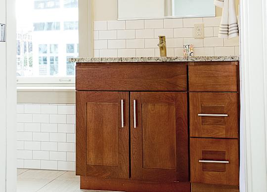 wooden cabinets and a sink and a mirror at 100 South Apartments, New York