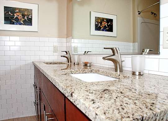 bathroom with a granite counter top and a sink at 100 South Apartments, Buffalo, 14202